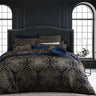 Experience the allure and grandeur of French Rococo design with the Davinci Peron Night Bed Quilt Cover Set. This exquisite ensemble pays homage to the decadence and drama of the era. The formal and symmetrical composition showcases large ornamental motifs enriched with metallic gold threads, set against a deep navy ground.