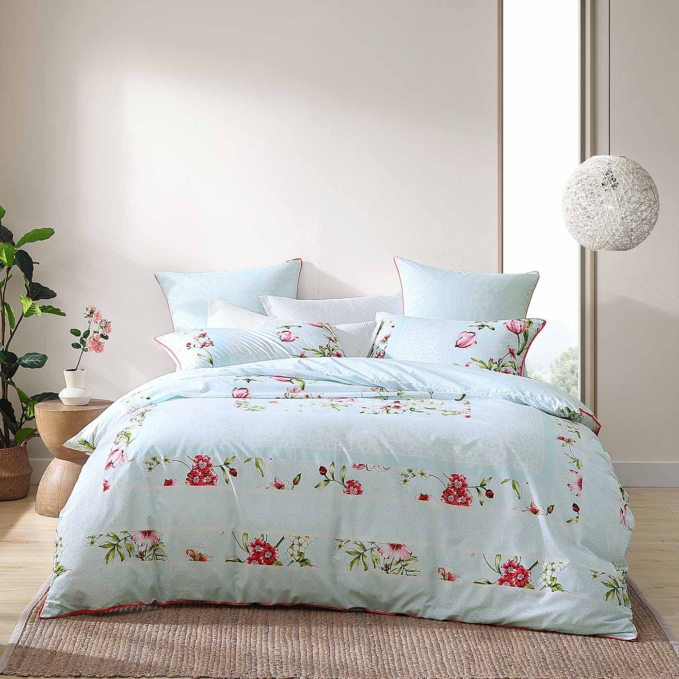 Posie Aqua is a fresh summer floral. Pink tulips, delicate yellow flowers and look a like white lacework are set into traditional panel format  borders. The design has a co ordinate lace inspired reverse and pops with the neon coral pink piping finish.