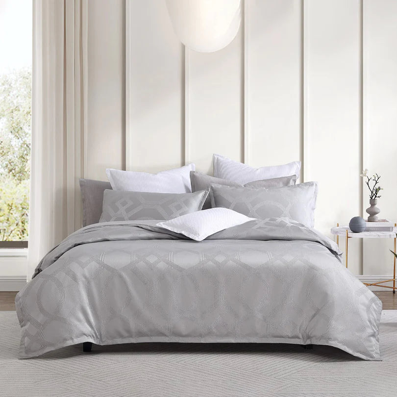 Infuse your bedroom with a touch of captivating Hollywood glamour through the Logan and Mason Platinum Seville Quilt Cover Set Range in Silver. This exquisite collection showcases a dazzling geometric pattern crafted with metallic yarn, while the addition of a self-flanged trim enhances its allure. Prepare to be mesmerized as the Seville set sparkles and shines from every angle.
