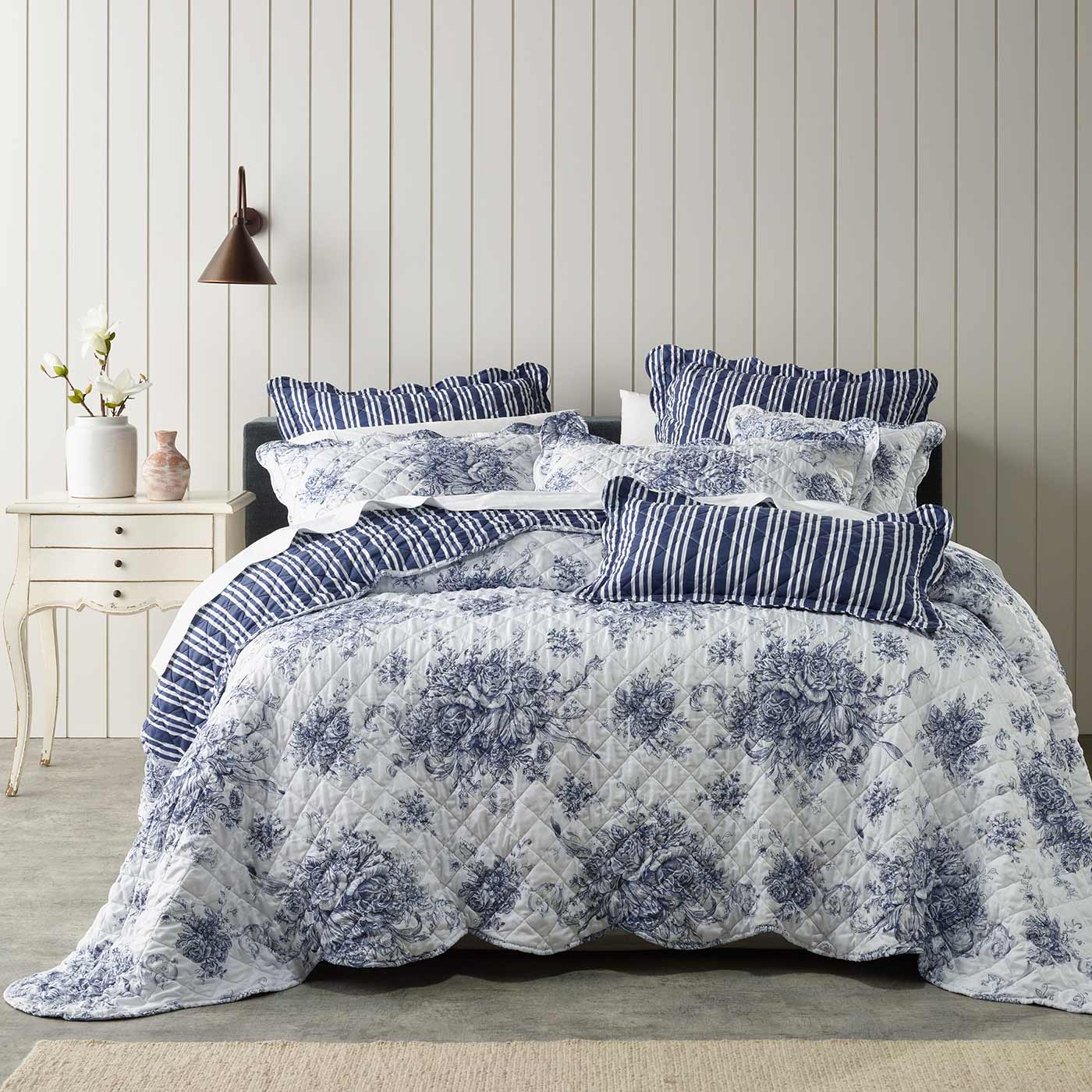 A stunning French Provincial inspired bedspread that features a scalloped edge. Traditional blue hues contrast beautifully on a white background. The bedspreads coordinate stripe printed reverse, also features on the european pillowcases and cushion.