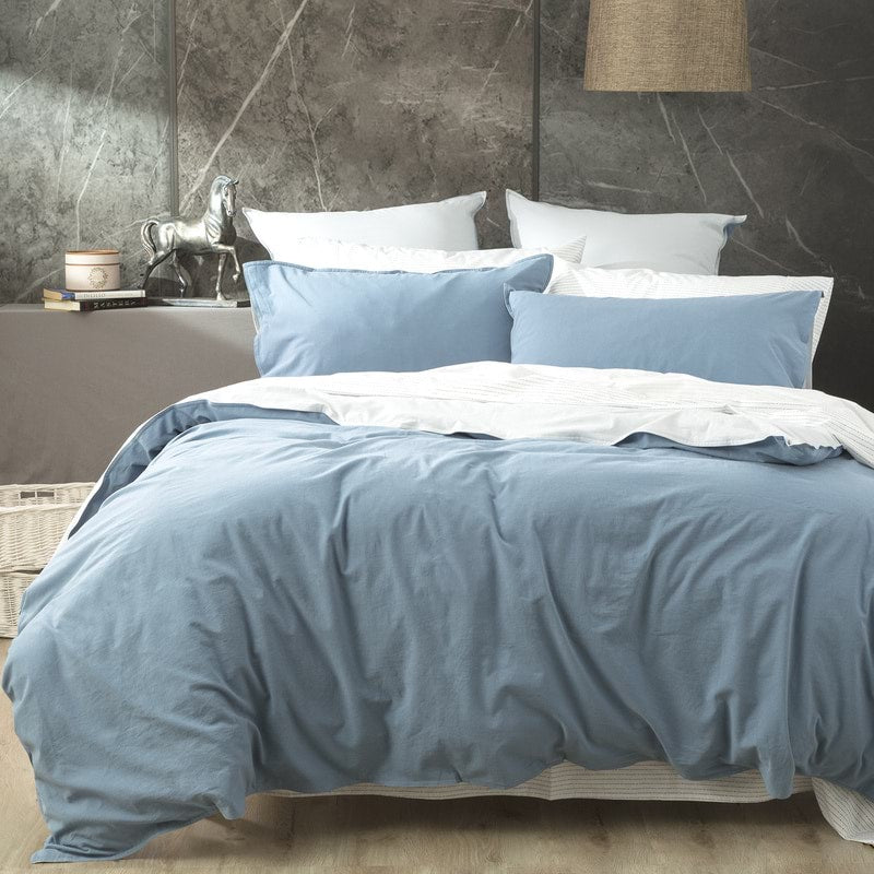 Create an effortlessly cool and inviting bedroom with the Blue Reversible Quilt Cover Set. Crafted from 100% cotton, this set from our Essentials Range offers a perfect blend of breathability and warmth, making it suitable for year-round use. The garment-dyed and stonewashed fabric gives it an airy, soft, and perfectly worn-in feel that will envelop you in comfort. 
