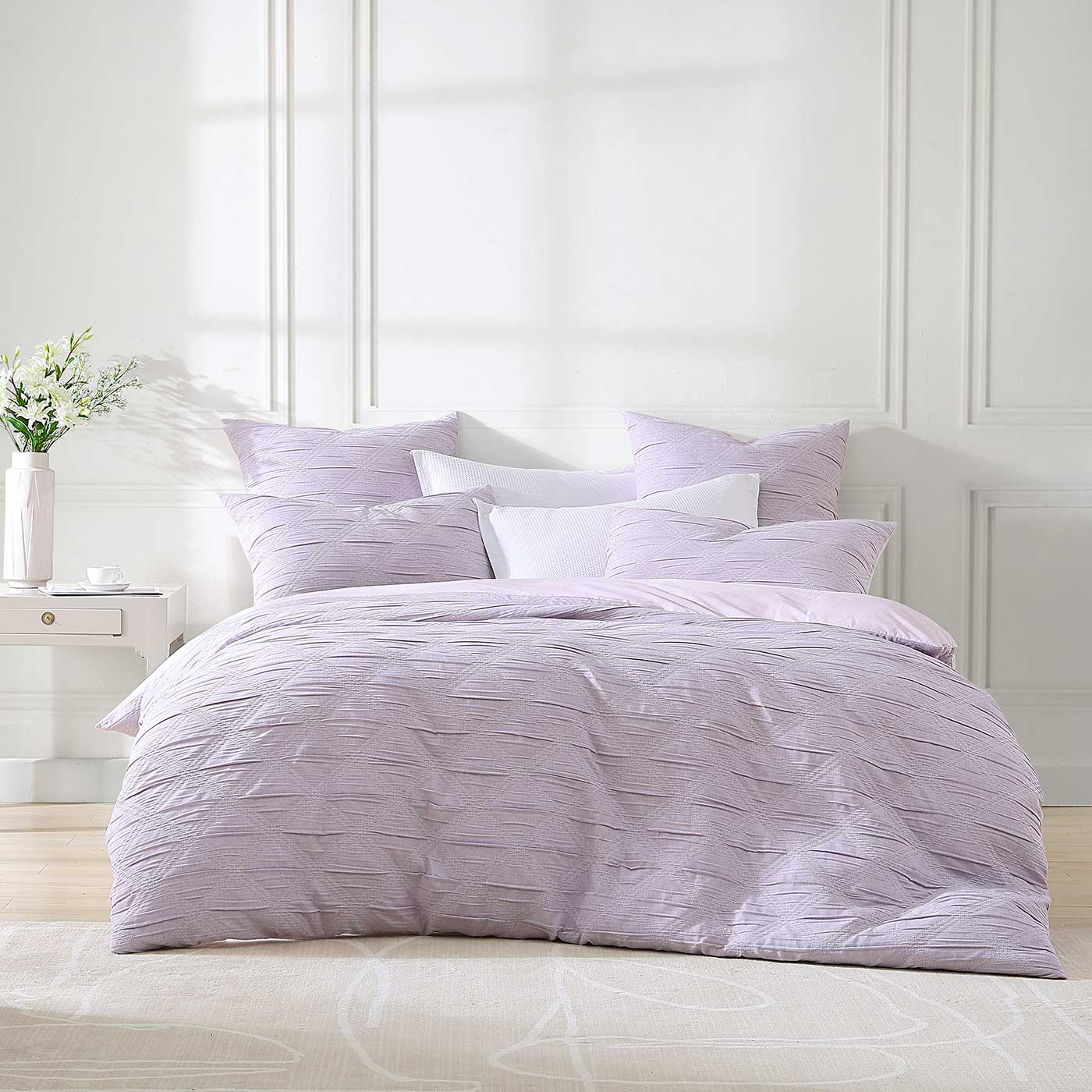 Create a bold statement in your bedroom with the Reine Lilac Quilt Cover Set. This luxurious set features an eye-catching monochrome diamond design