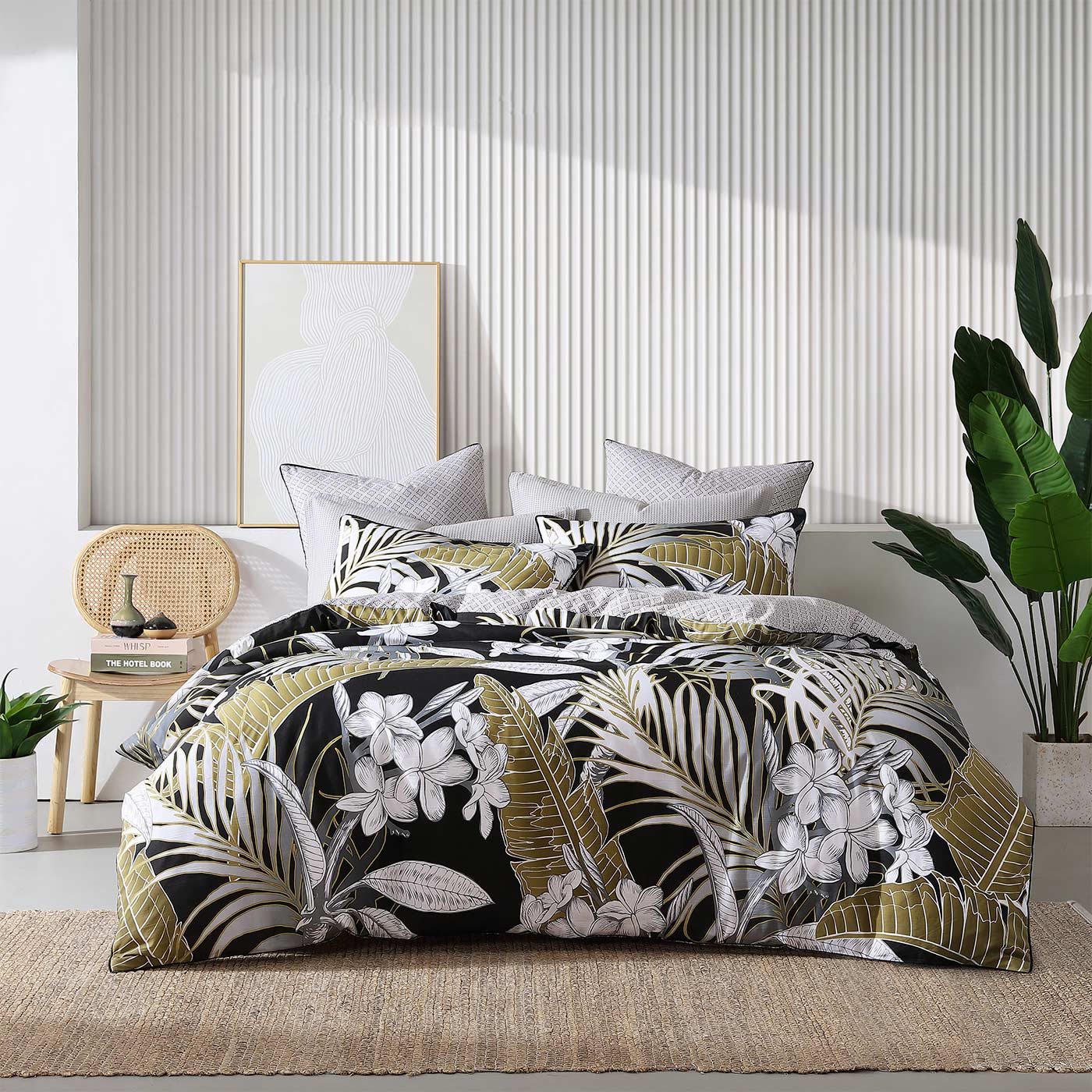 Tariq Black uses over scaled tropical foliage to cascade across the bed in a monochromatic colourway highlighted with tarnished gold.