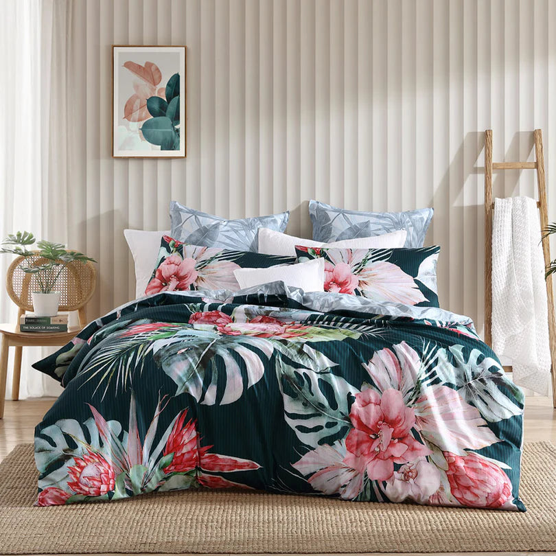 Experience the mesmerizing beauty of the Petra Quilt Cover Set Range Teal by Logan and Mason as it showcases breathtaking large-scale watercolor protea flowers seamlessly blending with tropical palm leaves