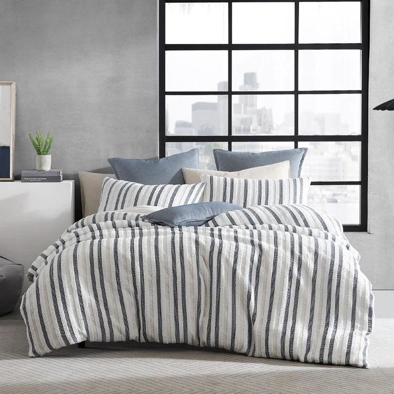 Experience the harmonious blend of soft chenille and a navy and white geometric design in a lineal pattern with the Boston Quilt Cover Set Range White by Logan and Mason Platinum. 